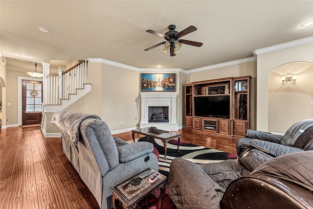 living room featuring ceiling fan, dark hardwood / wood-style floors, and ornamental molding