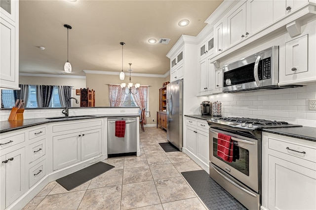 kitchen featuring appliances with stainless steel finishes, crown molding, sink, an inviting chandelier, and hanging light fixtures