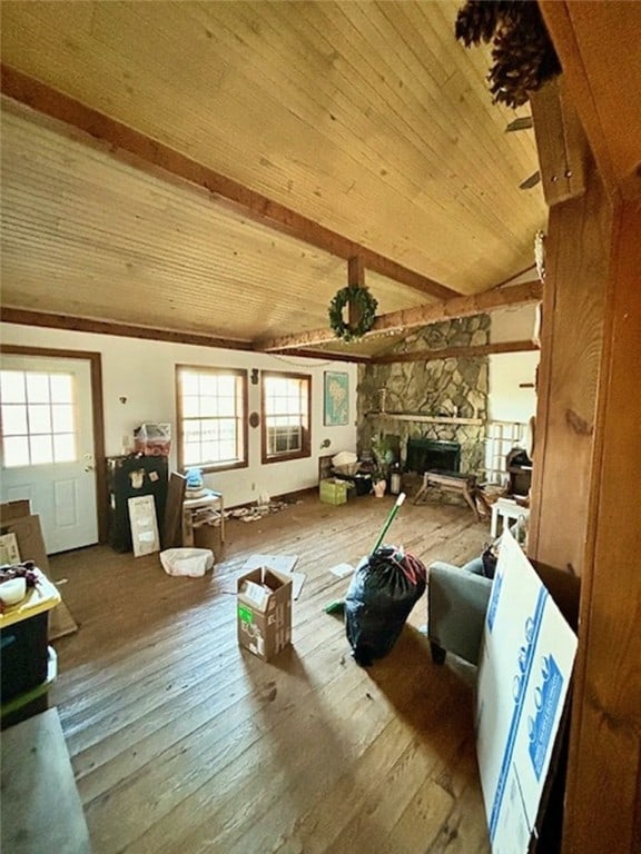 miscellaneous room featuring a fireplace, hardwood / wood-style floors, lofted ceiling with beams, and a healthy amount of sunlight