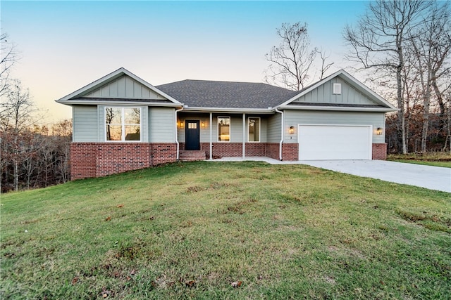 view of front facade featuring covered porch, a yard, and a garage