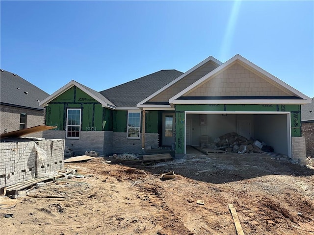 unfinished property featuring a garage, brick siding, and driveway