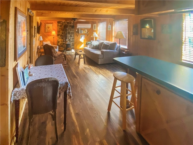 dining area featuring a wall unit AC, wooden walls, beam ceiling, wooden ceiling, and dark hardwood / wood-style floors