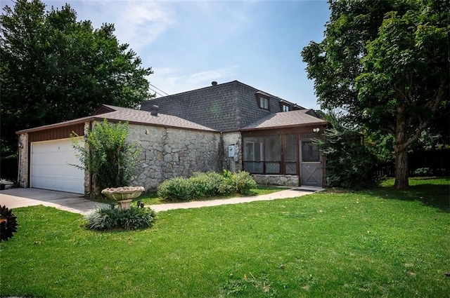 view of front of house featuring a front yard, a garage, and a sunroom