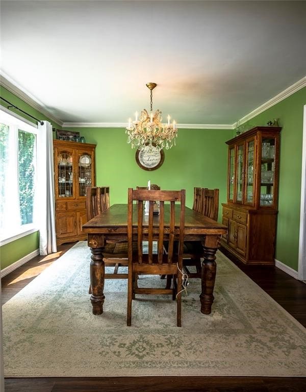 dining area featuring dark hardwood / wood-style floors, crown molding, and an inviting chandelier