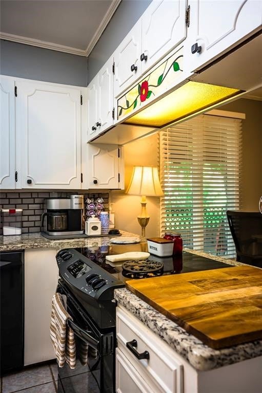 kitchen featuring white cabinets, tile patterned flooring, ornamental molding, and black electric range