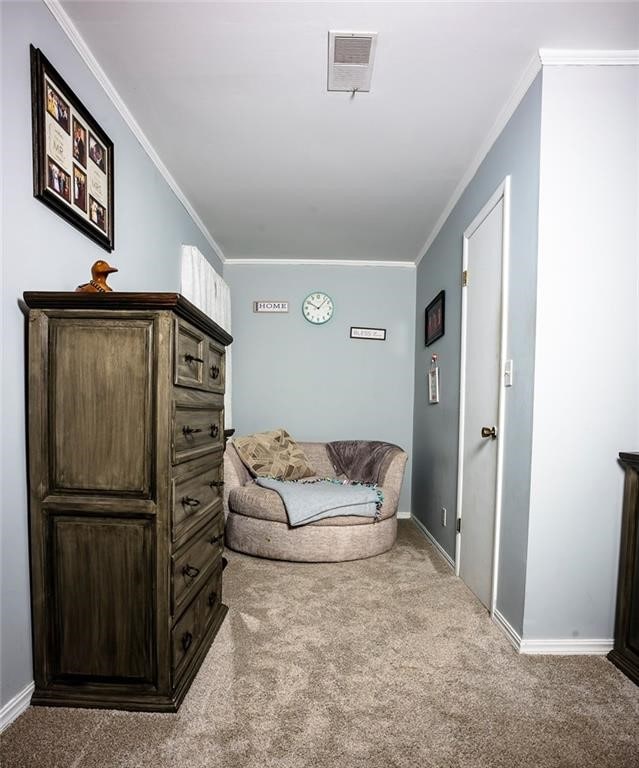 living area with light carpet and crown molding