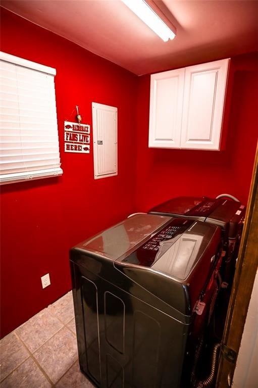 washroom with light tile patterned floors, cabinets, separate washer and dryer, and electric panel