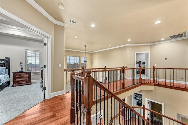 corridor featuring light hardwood / wood-style floors and crown molding