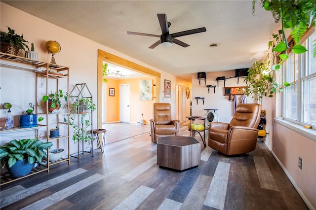 living room with a textured ceiling, dark hardwood / wood-style floors, and ceiling fan