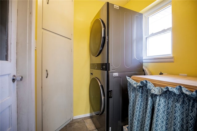 clothes washing area featuring stacked washing maching and dryer