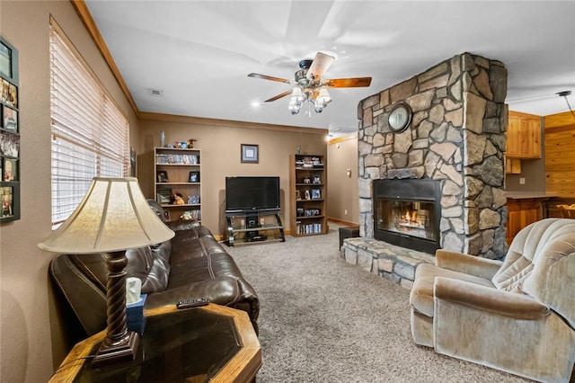 carpeted living room with ceiling fan, crown molding, and a fireplace