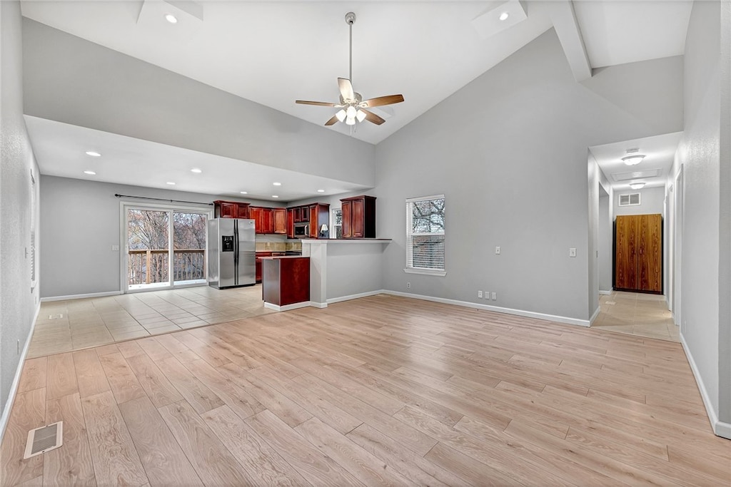 unfurnished living room featuring light hardwood / wood-style floors, high vaulted ceiling, and ceiling fan