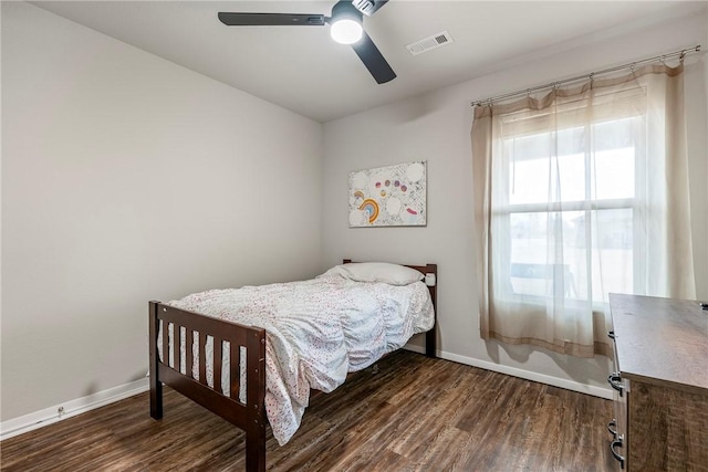 bedroom with dark hardwood / wood-style flooring and ceiling fan