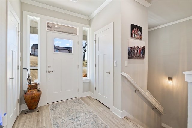 foyer entrance with crown molding and light hardwood / wood-style flooring