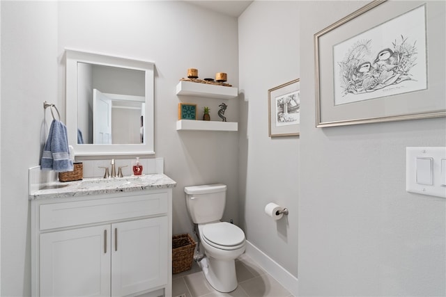 bathroom with tile patterned flooring, vanity, and toilet