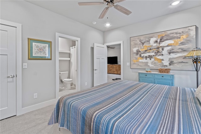 bedroom with a walk in closet, ensuite bath, ceiling fan, light colored carpet, and a closet