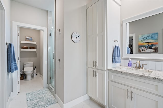 bathroom with vanity, a shower with shower door, and toilet