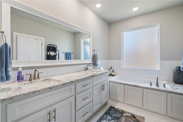 bathroom featuring tile patterned flooring, vanity, and a tub to relax in