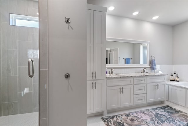 bathroom featuring tile patterned flooring, vanity, and a shower with shower door