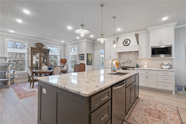 kitchen with white cabinetry, sink, stainless steel appliances, and light hardwood / wood-style flooring