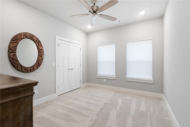 unfurnished bedroom with ceiling fan and light carpet