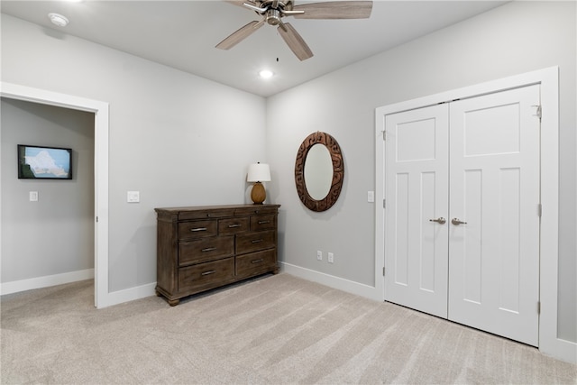 carpeted bedroom featuring ceiling fan and a closet