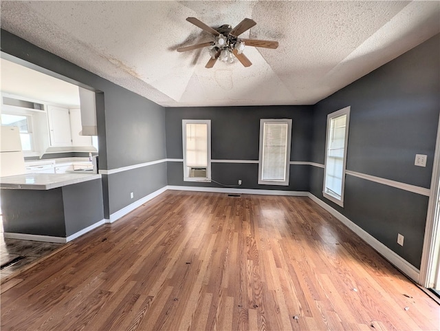 interior space featuring plenty of natural light, light hardwood / wood-style floors, a textured ceiling, and ceiling fan