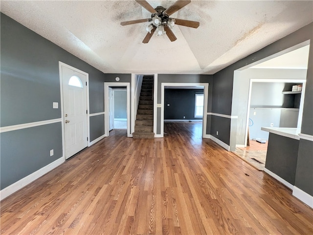 unfurnished living room with a textured ceiling, light hardwood / wood-style floors, built in features, and ceiling fan