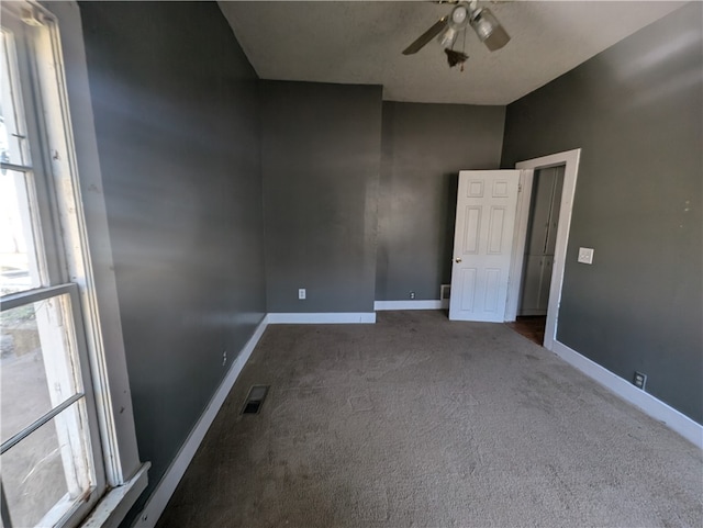 empty room featuring dark colored carpet and ceiling fan