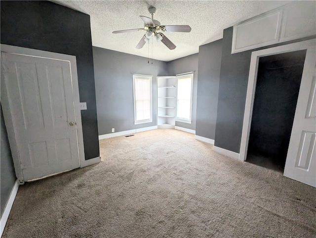 unfurnished bedroom featuring ceiling fan, carpet, and a textured ceiling