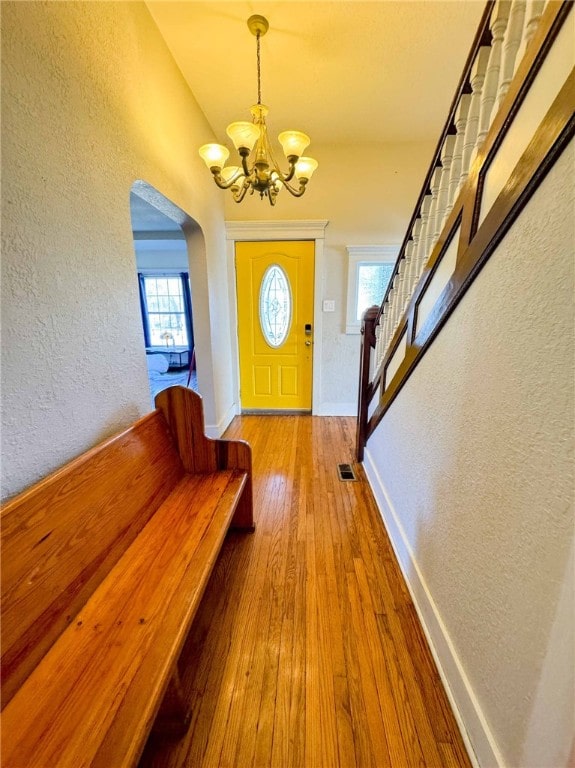 foyer entrance featuring light hardwood / wood-style flooring and a notable chandelier