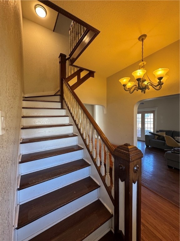 stairs with a notable chandelier and wood-type flooring