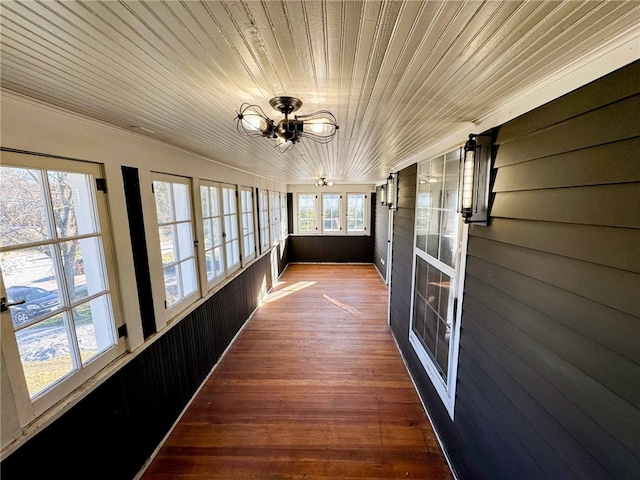 unfurnished sunroom featuring ceiling fan and wood ceiling