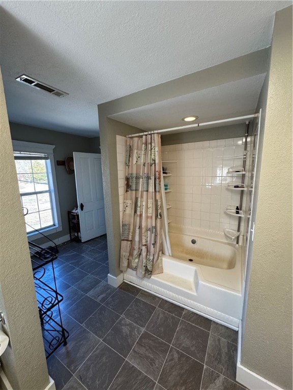 bathroom featuring a textured ceiling, tile patterned floors, and shower / bathtub combination with curtain