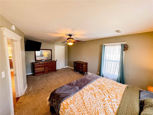 bedroom featuring ceiling fan, carpet floors, and a textured ceiling