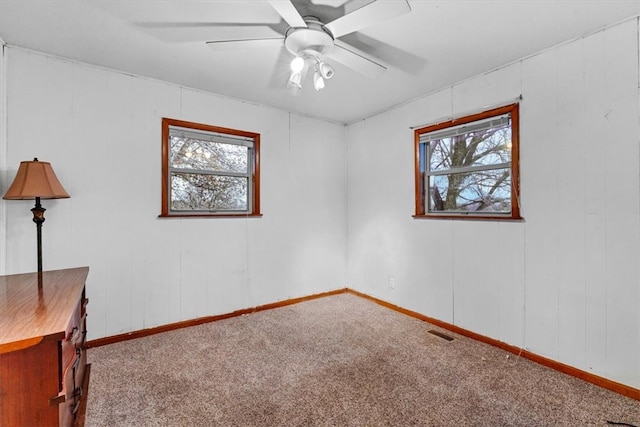 spare room with ceiling fan, carpet, and a healthy amount of sunlight