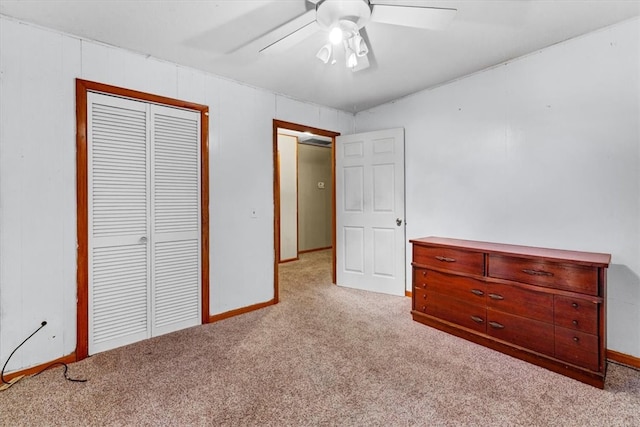 unfurnished bedroom with a closet, light colored carpet, and ceiling fan