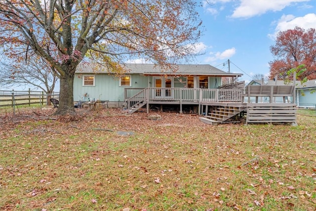 back of property featuring a lawn and a deck