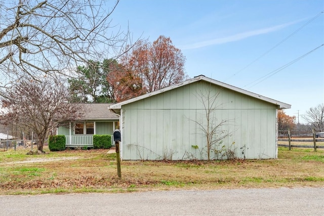 view of side of home with a lawn and a porch