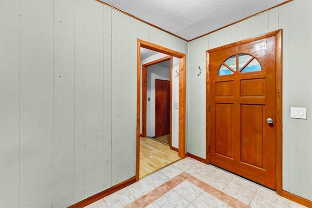 entryway featuring wooden walls, light hardwood / wood-style flooring, and crown molding