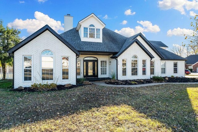 french country home with a front lawn