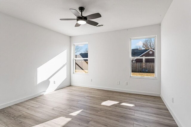 unfurnished room with light hardwood / wood-style flooring, a wealth of natural light, and ceiling fan