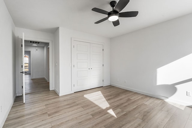 unfurnished bedroom featuring ceiling fan, light hardwood / wood-style floors, and a closet