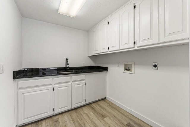 washroom featuring electric dryer hookup, cabinets, sink, hookup for a washing machine, and light hardwood / wood-style flooring