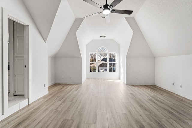 bonus room featuring ceiling fan, light hardwood / wood-style floors, a textured ceiling, and vaulted ceiling