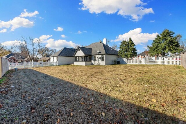 back of house with a lawn and a sunroom