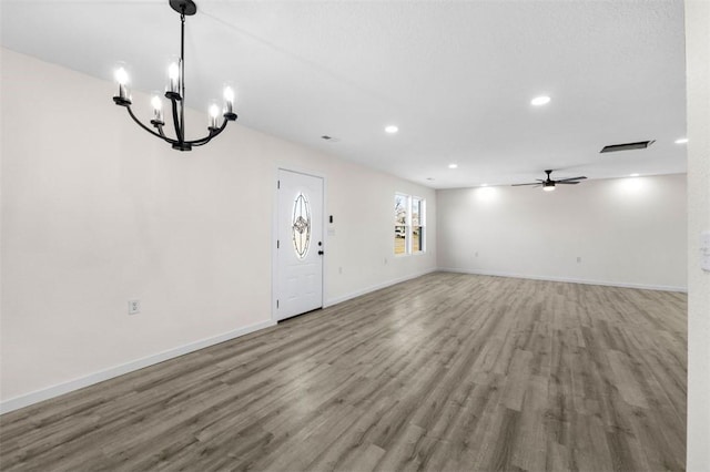 unfurnished living room with hardwood / wood-style flooring and ceiling fan with notable chandelier