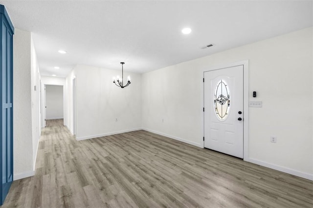 entrance foyer featuring an inviting chandelier and light hardwood / wood-style flooring