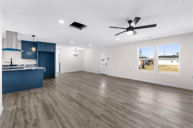 unfurnished living room with dark hardwood / wood-style floors and ceiling fan with notable chandelier