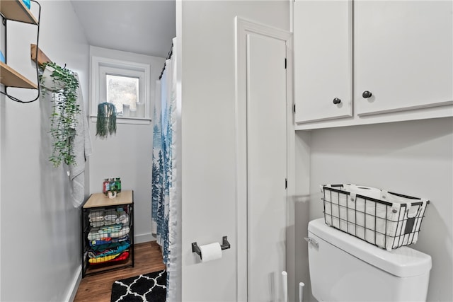 bathroom with hardwood / wood-style floors and toilet